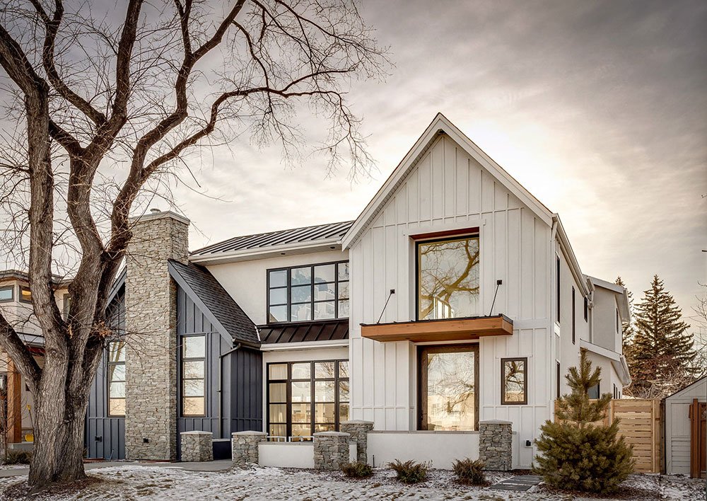 Modern Two-Tone Farmhouse Facade with Vertical Siding and Stone Elements