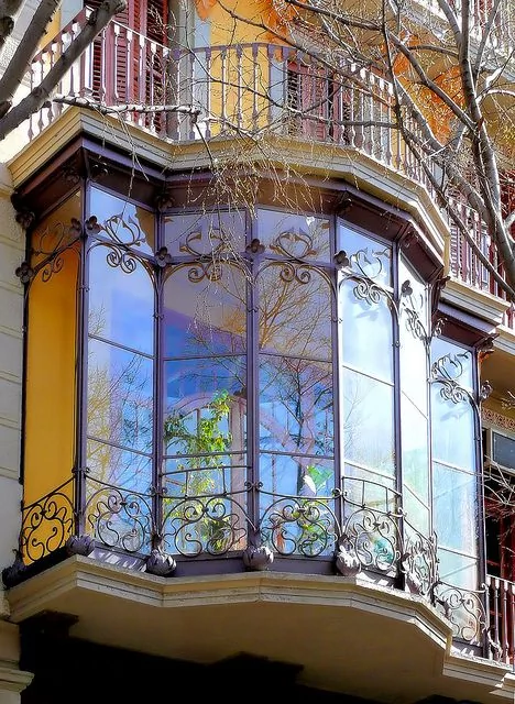 Elegant modernist bay window with stained glass and wrought iron facade decoration