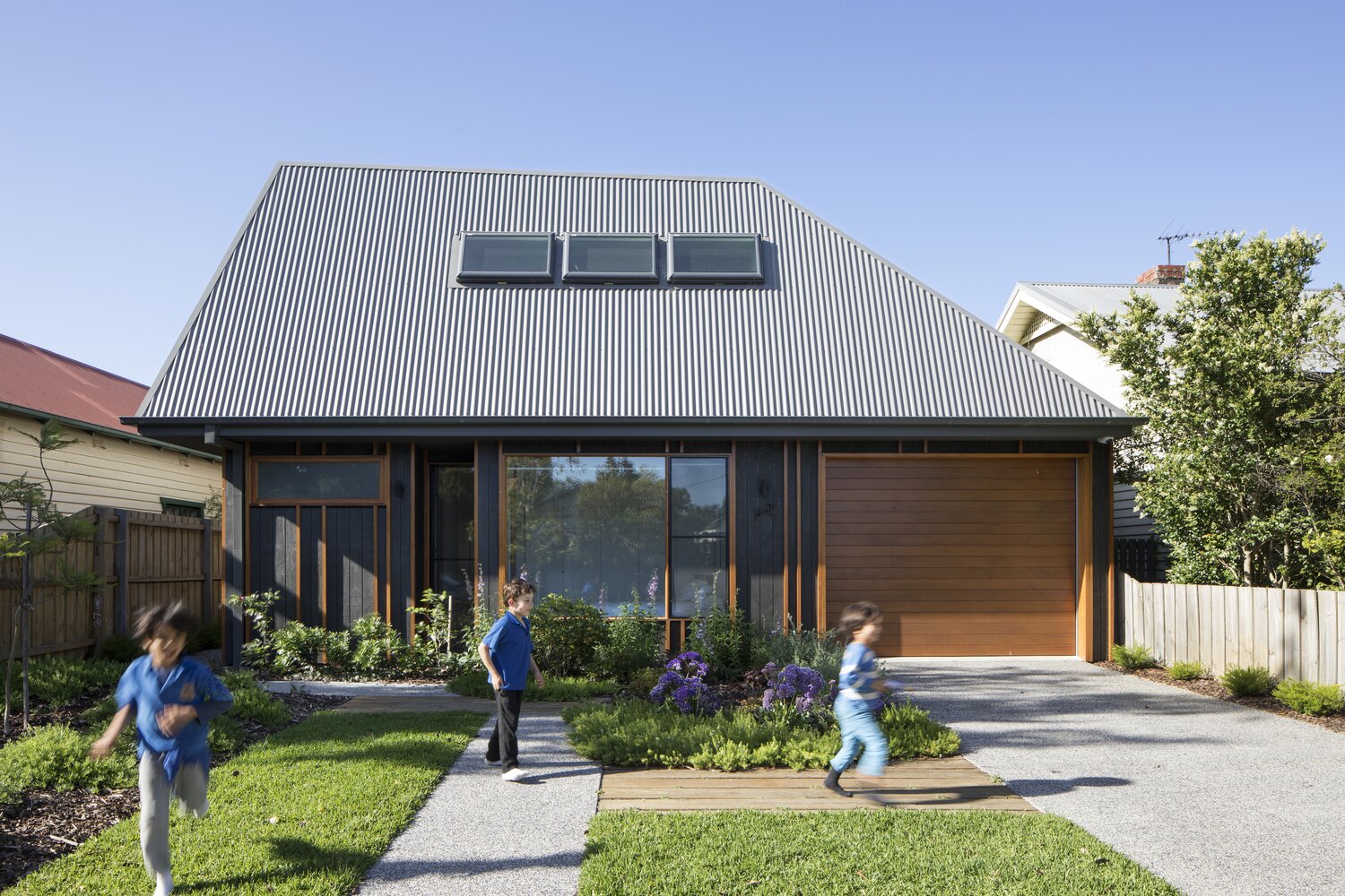 Modern façade with contrasting metal and wood combination under an unusual pitched roof