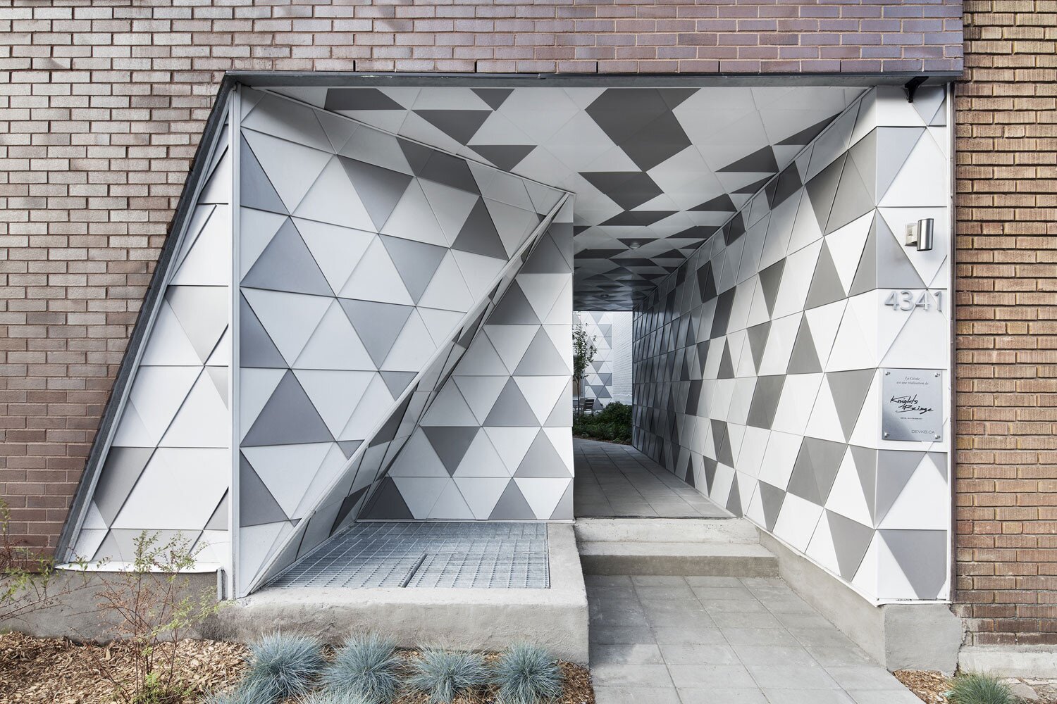 Geometric Facade with Triangular Texture: A Modern Portal in a Brick Building