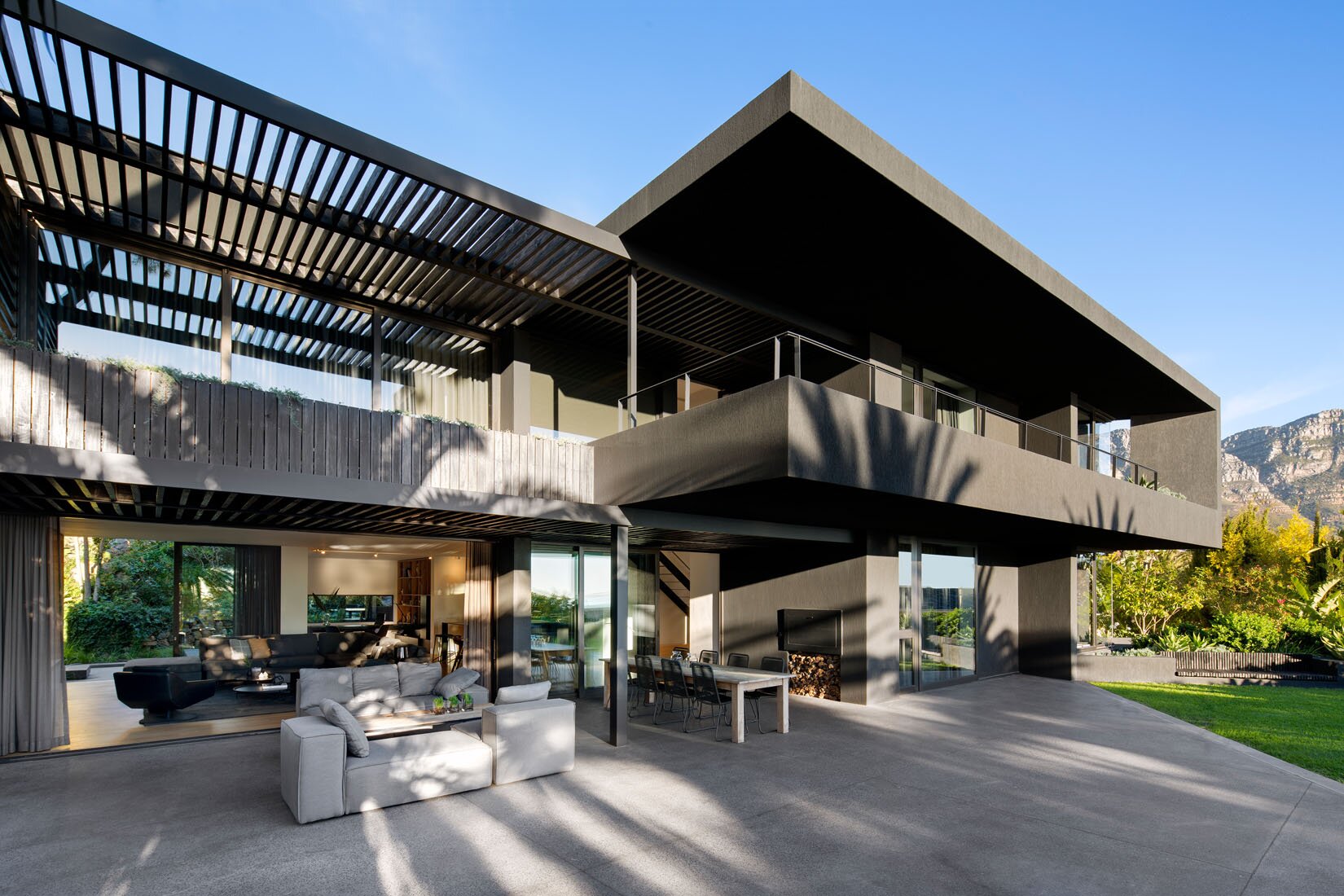 Modern minimalist facade with contrasting volumes and pergolas