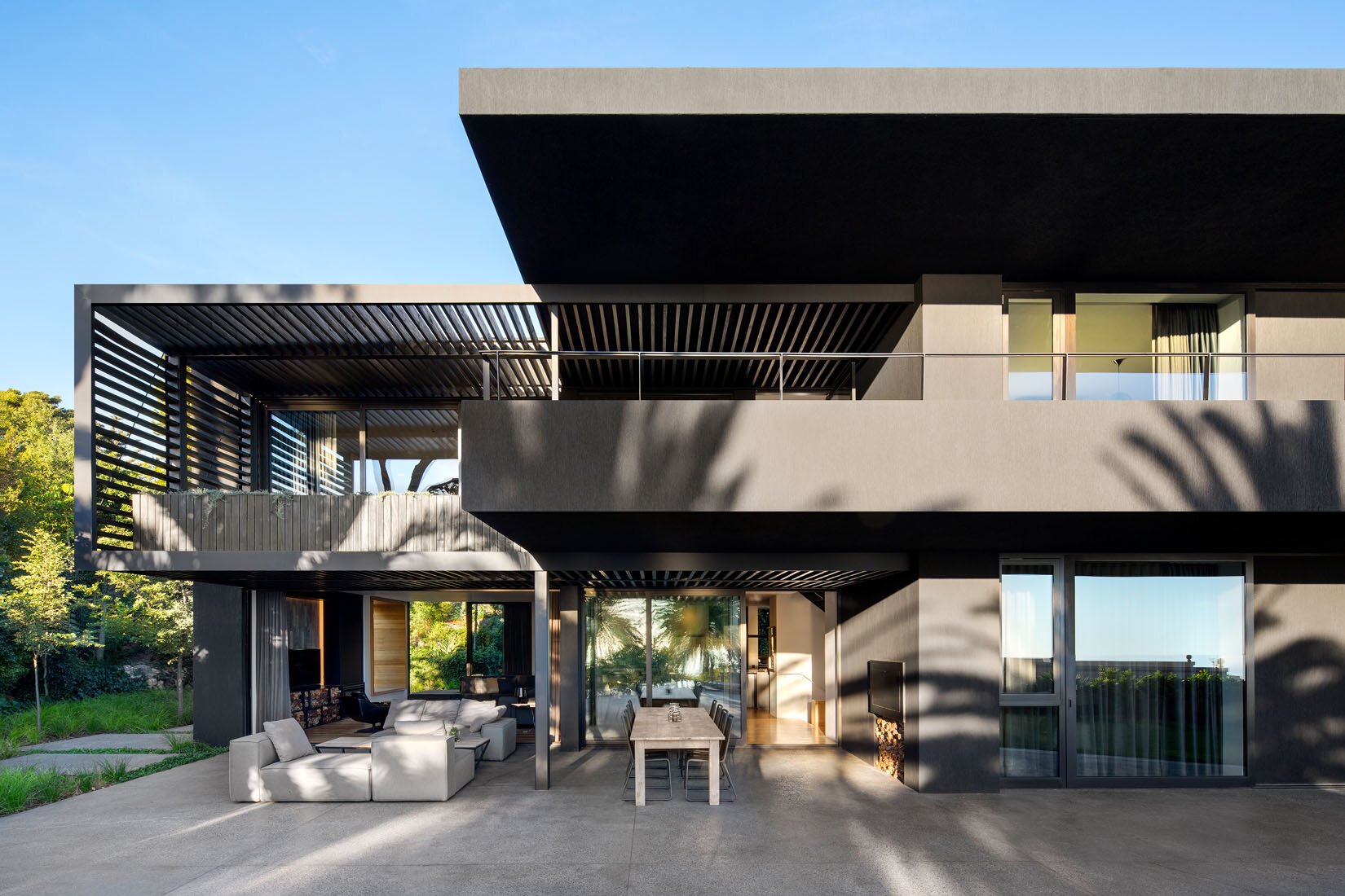 Modern minimalist facade with contrasting black and gray design and pergolas