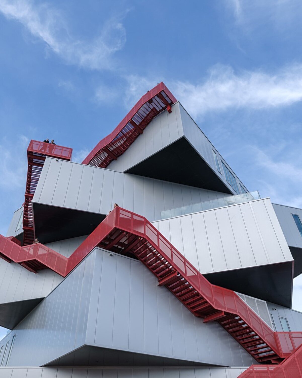 Modern facade with contrasting red staircase: geometry and minimalism