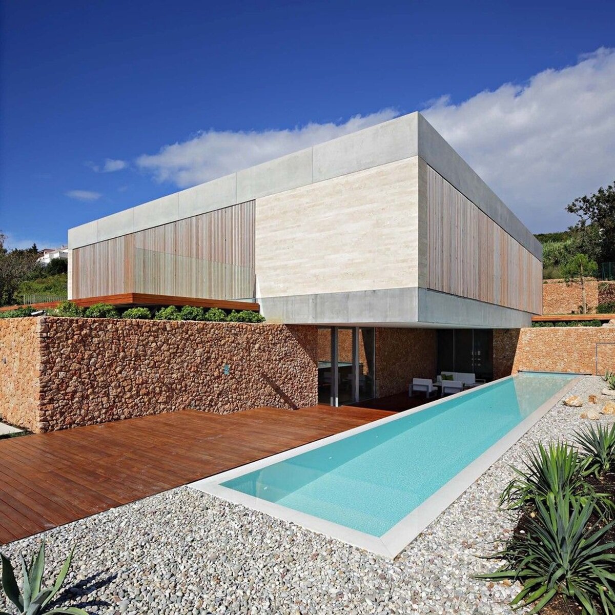 Modern facade with contrasting textures: wood, stone and concrete in minimalist design