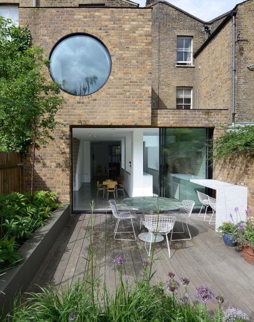 Modern Brick Facade Reconstruction with Circular Window and Panoramic Glazing