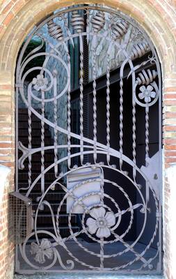 Art Nouveau Wrought Iron Grill with Floral Motifs in Brick Arched Facade