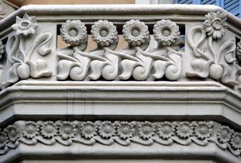 White Stone Decorative Frieze with Floral Motifs on a Historic Facade