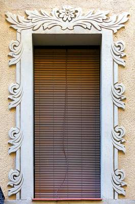 Window with exquisite carved framing on a light facade