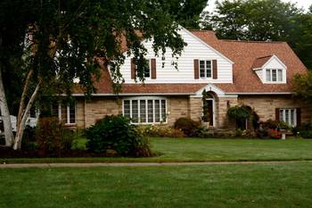 Two-story country house with combined façade: stone and siding