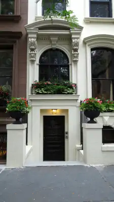 Elegant Neoclassical Townhouse Facade with Arched Window and Decorative Elements