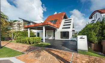 Futuristic Facade: House with Terracotta Triangular Roof and Snow-White Geometric Volumes