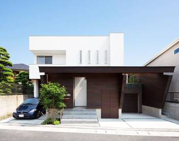 Contrasting Facade: White Minimalism and Dark Wood