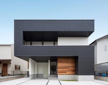 Contrasting Minimalism: Contemporary Residential Facade with Dark Gray Cladding and Wooden Accents