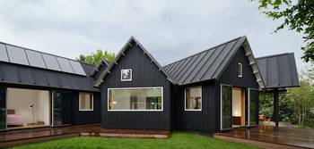 Black Scandinavian Façade: Modern Home with Vertical Wooden Cladding and Distinctive Triangular Gables