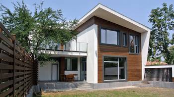 Modern residential house with contrasting façade: combination of wood and white stucco under a dynamic single-slope roof