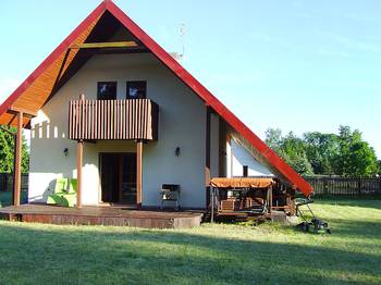 A-frame country house facade with contrasting red roof and wooden elements