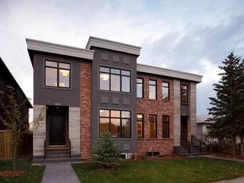 Modern duplex with combined facade of brick, stucco, and stone