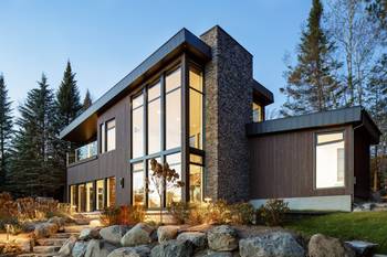 Modern forest house with contrasting wood and stone facade