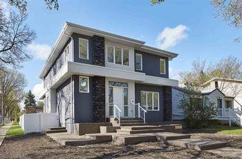 Modern two-story house with contrasting gray-white facade and stone accents