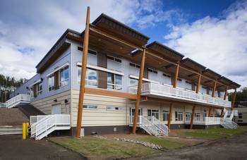 Modern two-story facade with contrasting cladding and wooden supports