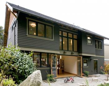 Modern two-story house with minimalist dark gray facade and panoramic glazing