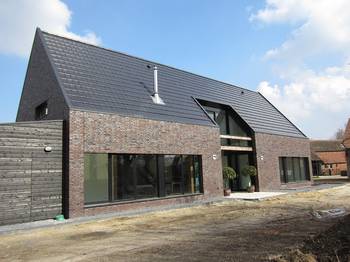 Modern brick facade with contrasting roof and wooden elements