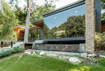 Modern Façade with Waterfall: Harmony of Glass, Wood and Stone