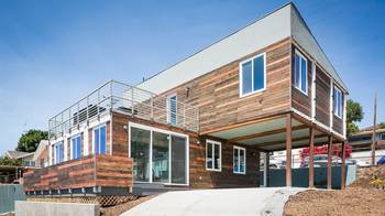 Modern two-story house with wooden facade and contrasting elements