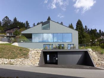 Minimalist Hillside Facade: Interplay of Geometry, Glass and Stone