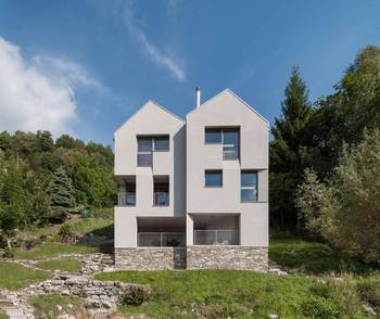 Dualistic Facade: Minimalist White Volumes on Stone Foundation