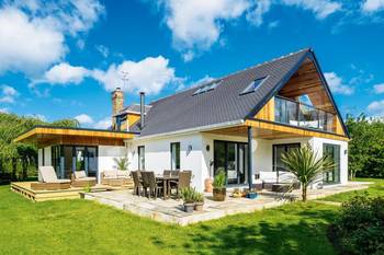 Modern country house with contrasting facade: combination of white plaster and wooden cladding