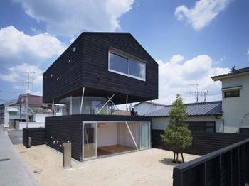 Black Floating Facade: Minimalist Two-Level House with Elevated Second Floor