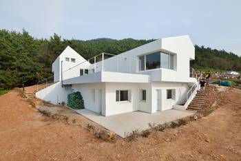 White Minimalist Façade: Two-Level House with Geometric Composition on Forest Hillside