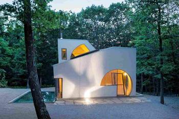 Geometric facade with circular accents: minimalism in a forest setting