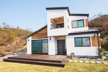 Modern two-story house with contrasting white and wooden facade