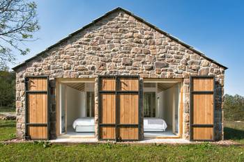 Modern Stone Façade with Wooden Sliding Elements: Traditions in a New Interpretation