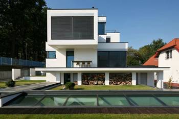 White modernist facade with dynamic geometry and integration of natural elements