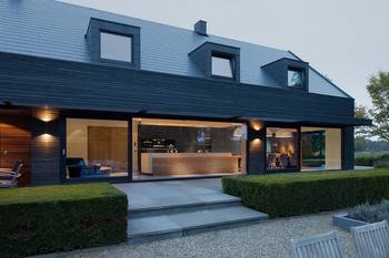 Modern two-level house with dark façade and panoramic glazing