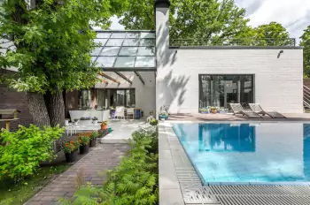 Modern white brick facade with panoramic glazing and integration into natural environment