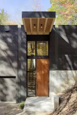 Contrasting minimalist facade with accented wooden portal
