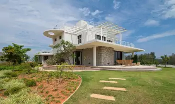 Modern villa with contrasting white-stone facade and flowing modernist lines