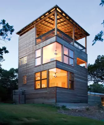 Vertical wooden facade: tower with panoramic glazing and open terrace