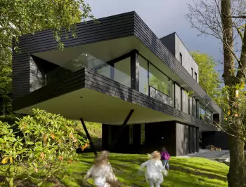Cantilevered House with Dark Timber Facade in Forest Setting