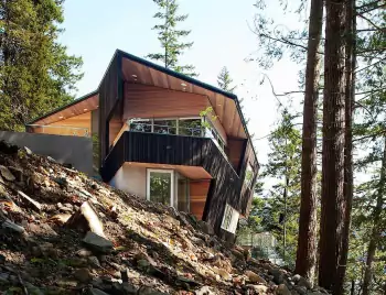 Dynamic facade: modern mountain house with contrasting finishes on a steep slope