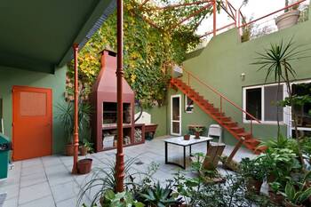 Mediterranean Courtyard: Green Facade with Terracotta Accents