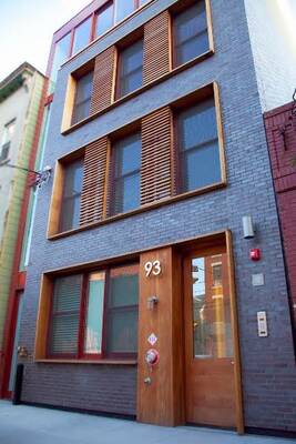 Urban Minimalism: Dark Brick Facade with Wooden Louvers