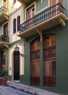 Colonial Facade with Mediterranean Motifs: Green and Cream in Perfect Harmony