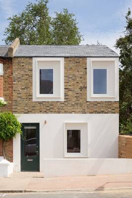 Two-story urban house with contrasting facade: brickwork and white plaster