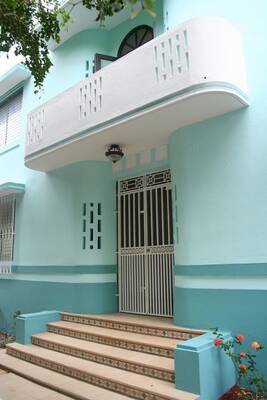 Turquoise Facade with Perforated Balcony: Tropical Elegance