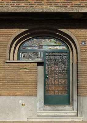 Brick facade with arched entrance and openwork metal door